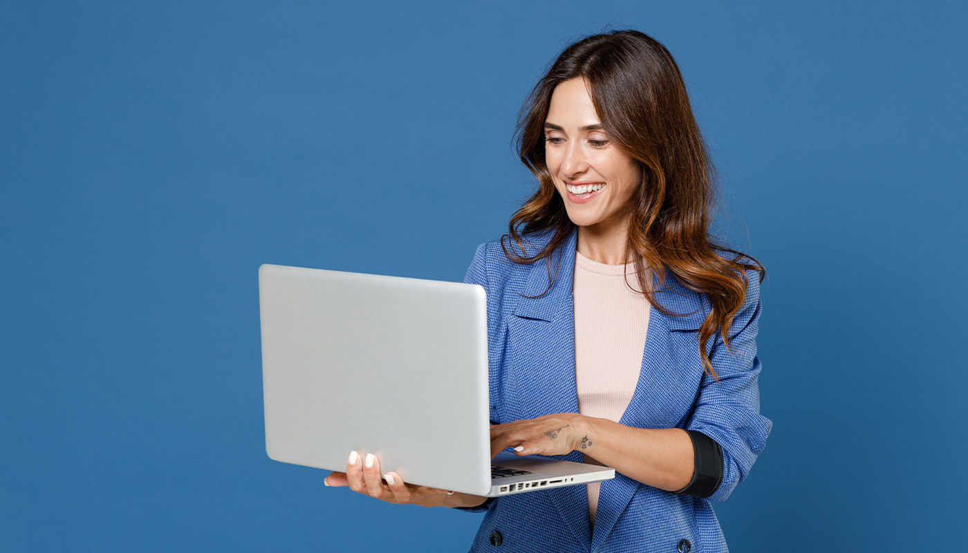 Woman holding laptop while working on it