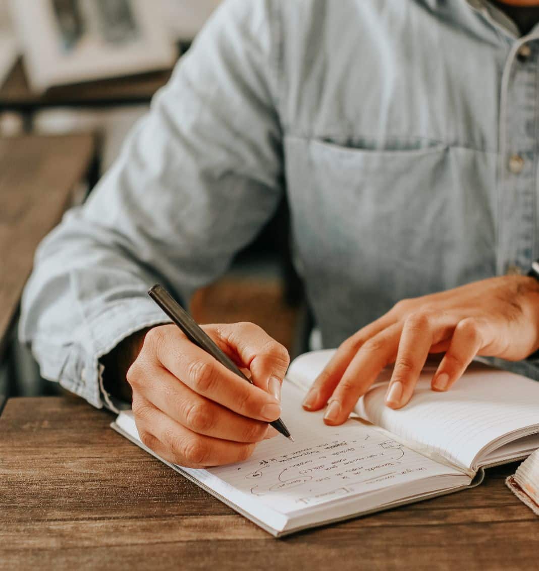 Man writing notes in booklet