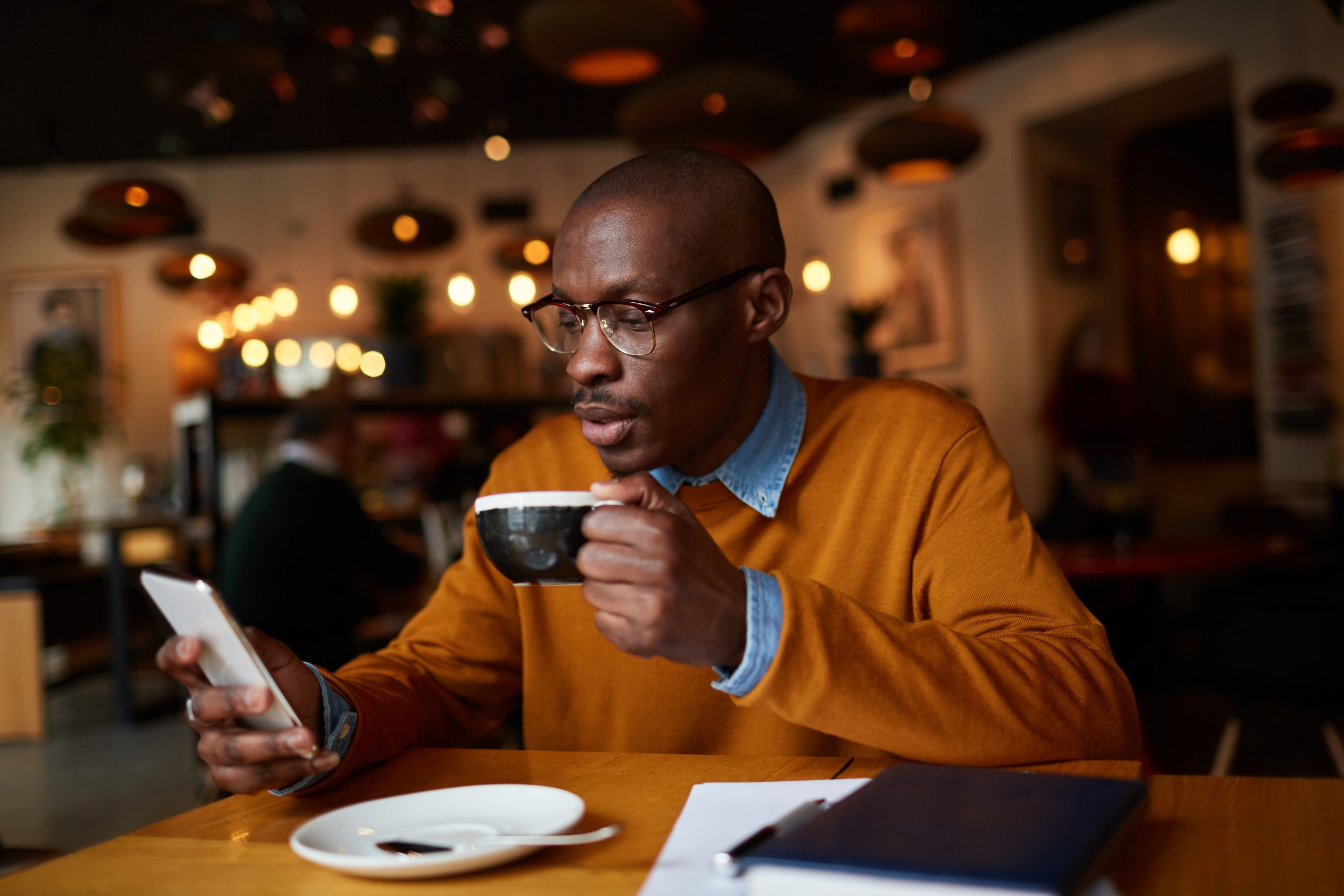Man drinking coffee while on his phone