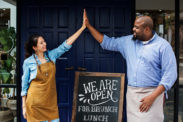 Small business owners celebrate outside of store