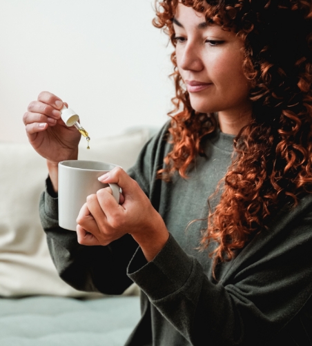 Woman putting oil into drink