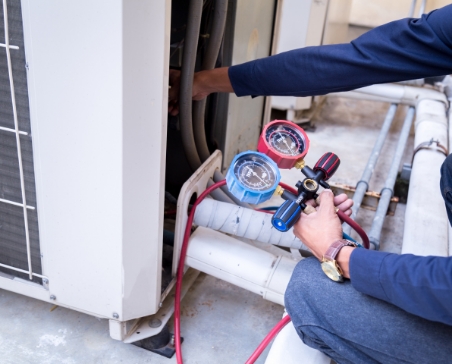 Person working with HVAC system and pressure indicators