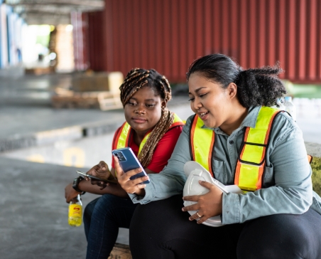 Women checking phone in a warehouse