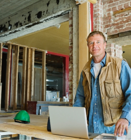 Construction worker on laptop at construction site