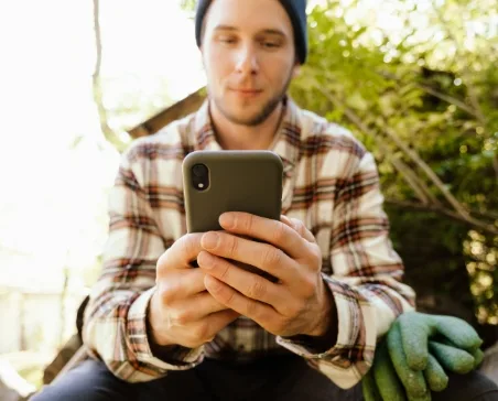 Landscape worker checking phone