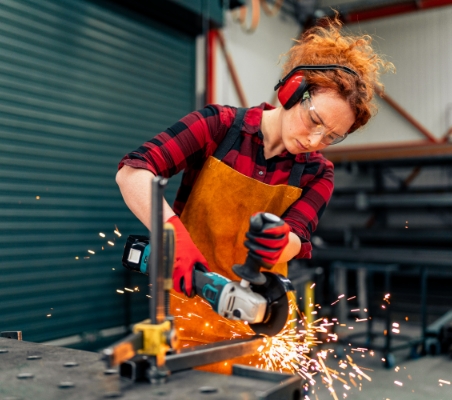 Woman using grinder to work on metal