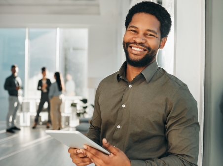 Man working while associates talk in background